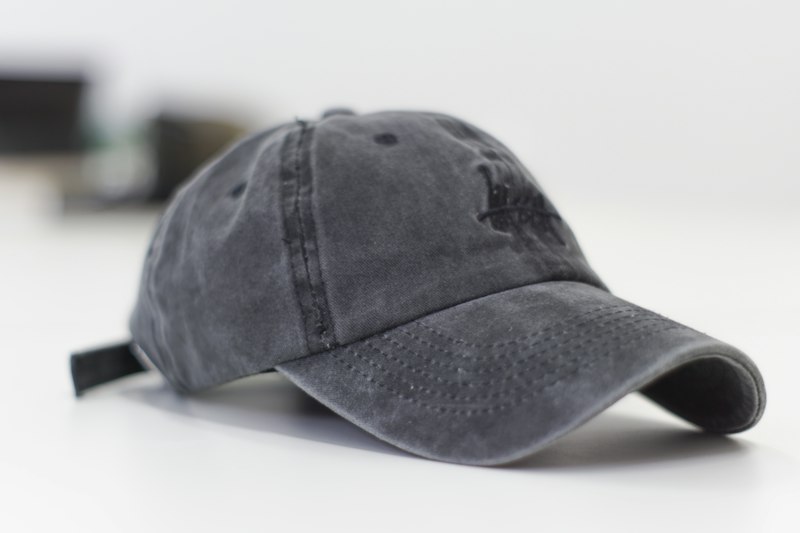 Embroidered baseball cap hanging on rack — custom headwear